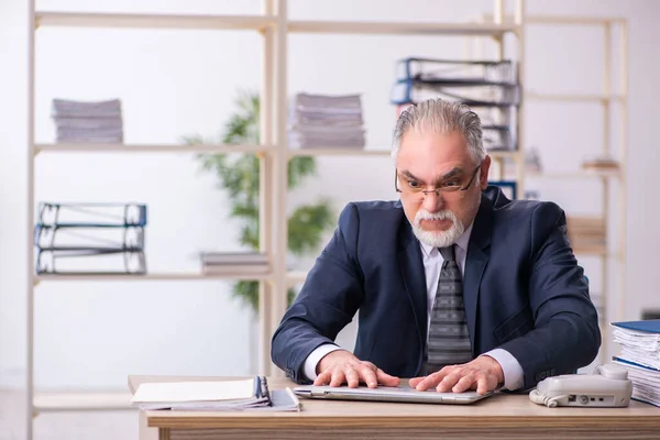 Gammal manlig anställd missnöjd med överdrivet arbete på kontoret — Stockfoto