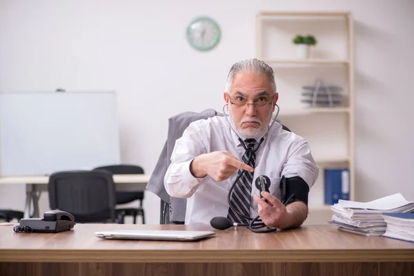 職場で苦しんでいる高齢男性従業員 — ストック写真