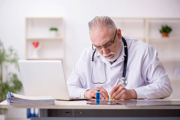 Gammal manlig läkare som arbetar på kliniken — Stockfoto