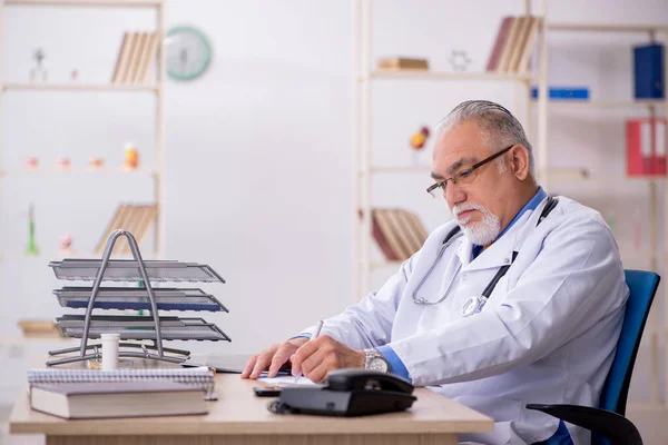 Starý lékař pracující na klinice — Stock fotografie