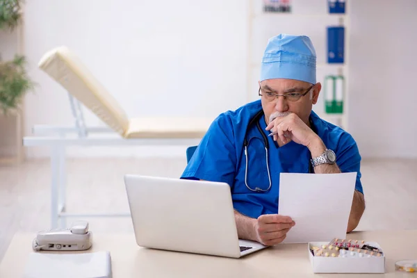 Starý lékař pracující na klinice — Stock fotografie