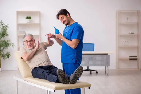Vecchio maschio paziente visting giovane maschio medico gastroenterologo — Foto Stock