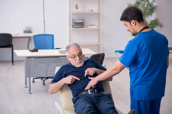 Yaşlı adam genç erkek doktoru ziyaret ediyor. — Stok fotoğraf