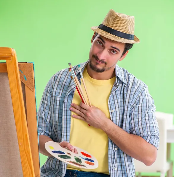 Młody artysta pracujący nad nowym malarstwem w swoim studio — Zdjęcie stockowe