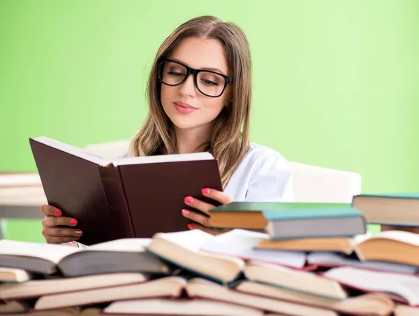 Jeune étudiante se préparant à des examens avec de nombreux livres — Photo