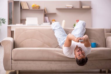 Genç erkek öğrenci salgın sırasında evde oturuyor.