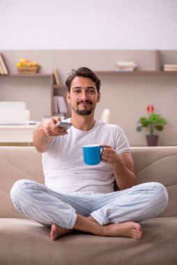 Genç erkek öğrenci salgın sırasında evde oturuyor.