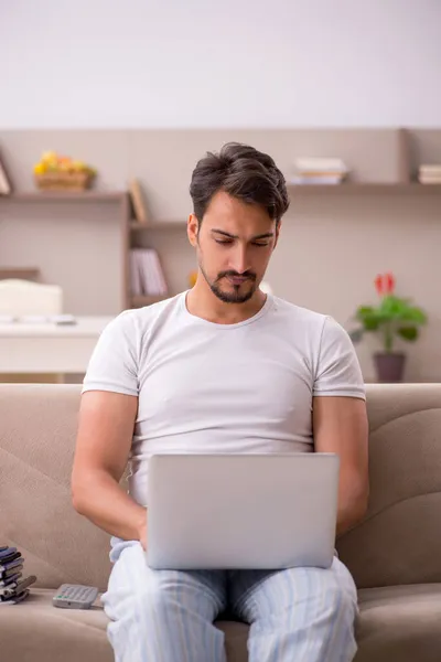 Ung manlig anställd som arbetar hemifrån under en pandemi — Stockfoto