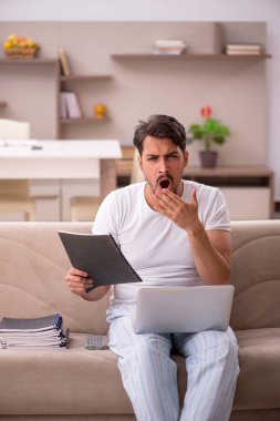 Genç erkek çalışan salgın sırasında evden çalışıyor.