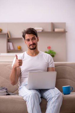 Genç erkek çalışan salgın sırasında evden çalışıyor.