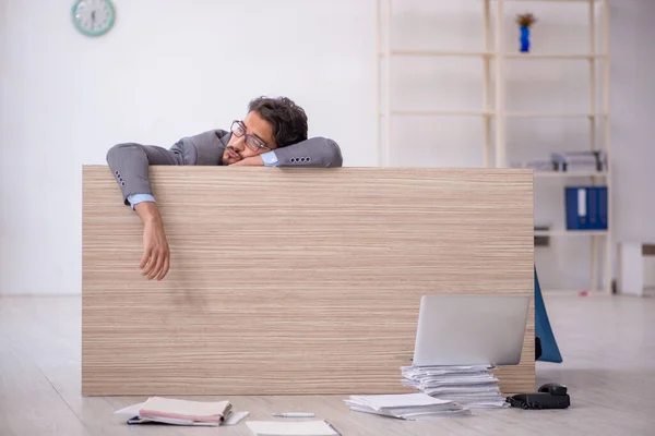 Jovem empregado do sexo masculino trabalhando horas extras no escritório — Fotografia de Stock