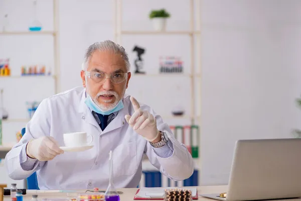 Antiguo químico masculino en concepto de síntesis de fármacos — Foto de Stock