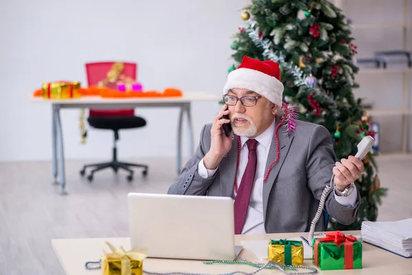 Funcionário idoso do sexo masculino comemorando o Natal no local de trabalho — Fotografia de Stock