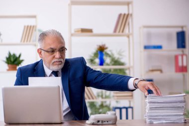 Ofiste çalışan yaşlı bir erkek.