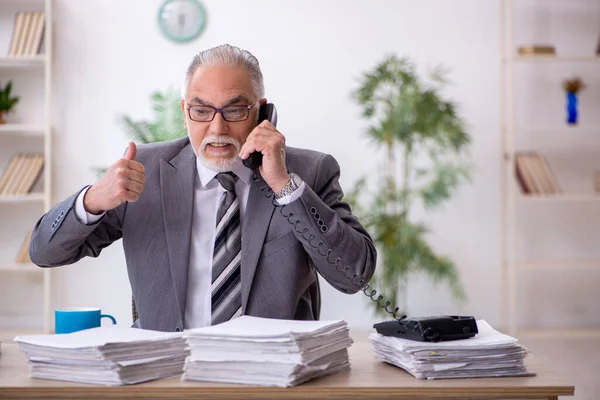 Velho empregado masculino e muito trabalho no escritório — Fotografia de Stock