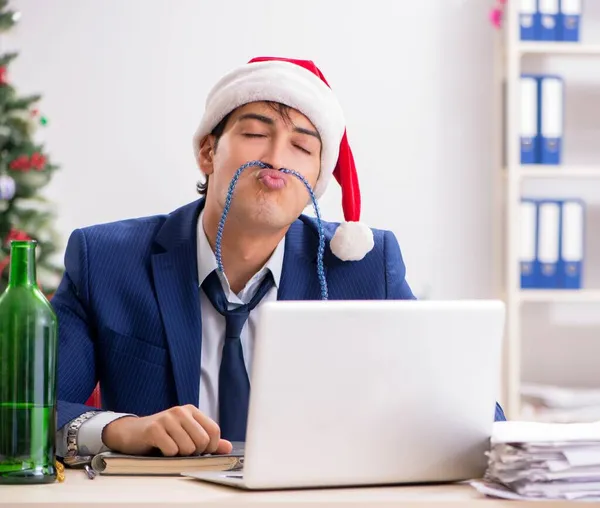 Joven empleado guapo celebrando la Navidad en el lugar de trabajo — Foto de Stock