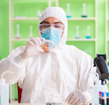 Laboratuvarda yeni bir deney üzerinde çalışan kimyager.