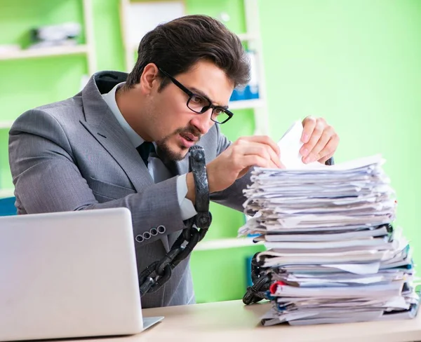Anställd fastkedjad vid sitt skrivbord på grund av arbetsbelastning — Stockfoto