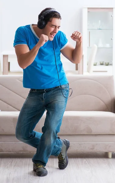 Ung vacker man lyssnar på musik och ha roligt hemma — Stockfoto
