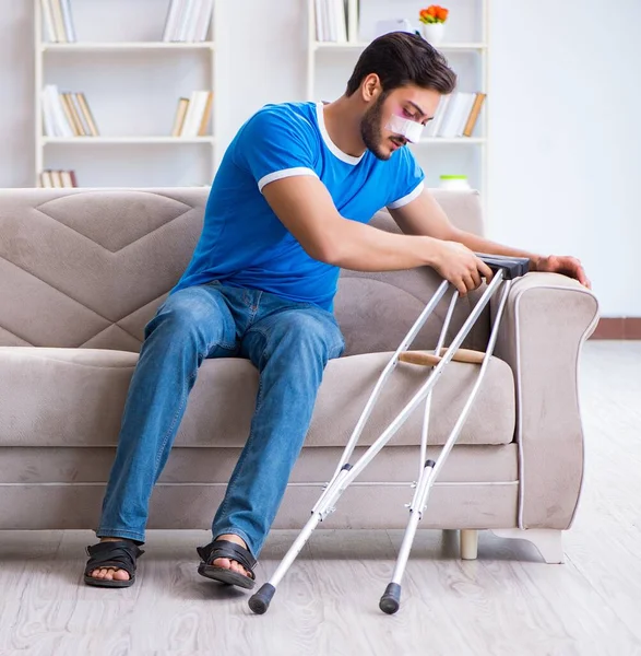 Homem ferido com muletas se recuperando em casa — Fotografia de Stock