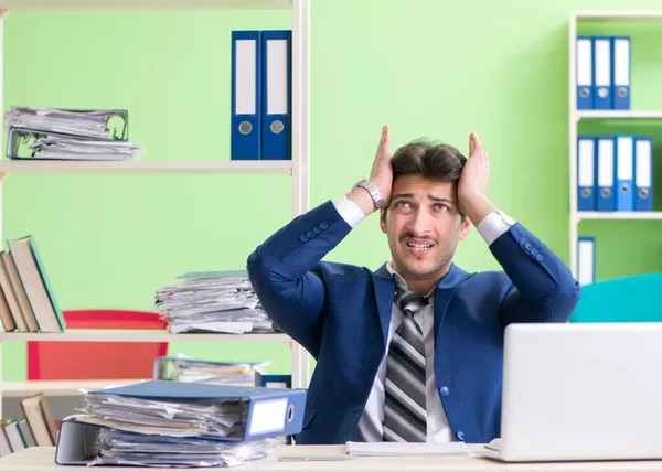 Empresario descontento con el trabajo excesivo sentado en la oficina — Foto de Stock