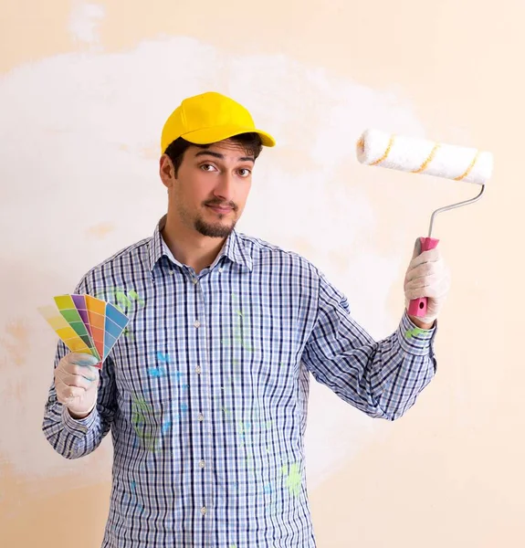 Pintor homem pintando a parede em casa — Fotografia de Stock