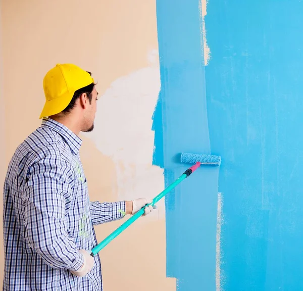 Painter man painting the wall at home — Stock Photo, Image