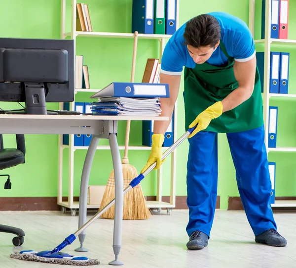 Erkek yakışıklı profesyonel temizlikçi ofiste temizlik yapıyor. — Stok fotoğraf