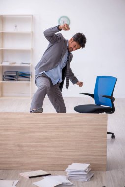 Genç erkek çalışan ofiste fazla mesai yapıyor.