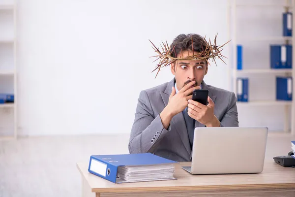 Junge männliche Angestellte trägt stacheligen Kranz auf dem Kopf — Stockfoto