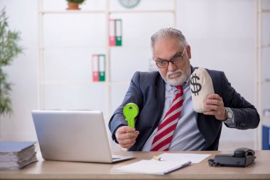 İş yerinde maaş konseptinde çalışan yaşlı bir erkek.