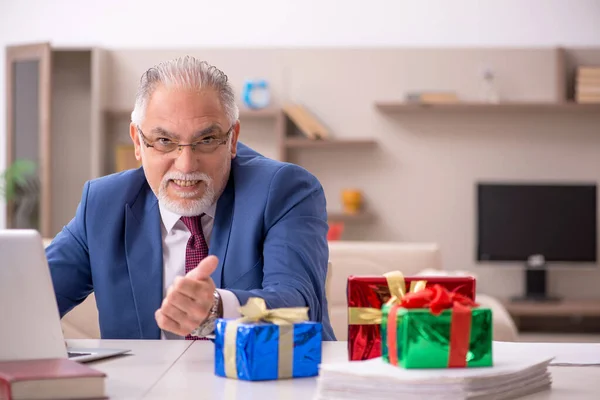 Velho funcionário do sexo masculino comemorando o Natal em casa — Fotografia de Stock