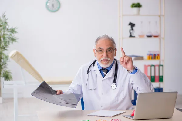 Starý lékař radiolog pracující na klinice — Stock fotografie