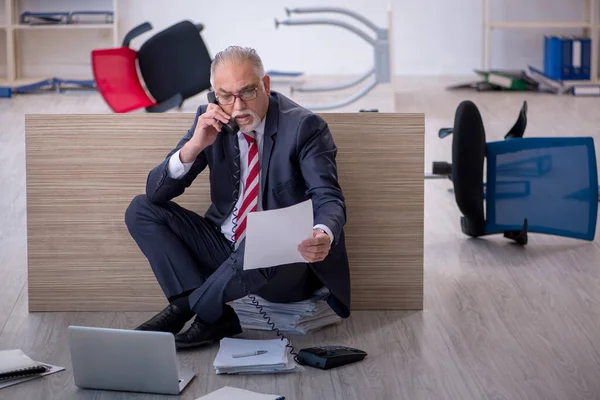 Oude mannelijke werknemer die overuren maakt op kantoor — Stockfoto