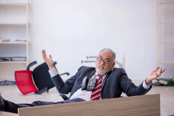 Gammal manlig anställd som arbetar övertid på kontoret — Stockfoto