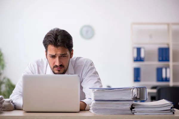 Junge männliche Angestellte unzufrieden mit exzessiver Arbeit im Büro — Stockfoto