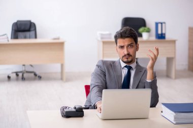 Ofiste çalışan genç bir erkek.