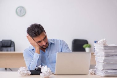 Genç bir erkek çalışan ofiste yeni fikirleri reddediyor.