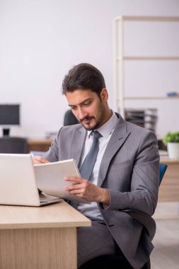 Ofiste çalışan genç bir erkek.