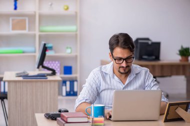 Ofiste çalışan genç bir erkek.