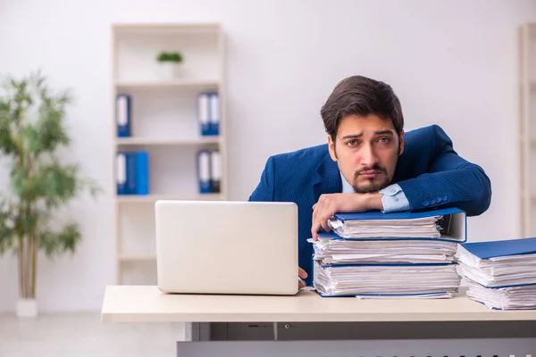 Jovem funcionário masculino infeliz com excesso de trabalho no escritório — Fotografia de Stock