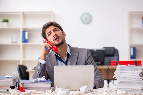 Joven empleado masculino y demasiado trabajo en la oficina — Foto de Stock