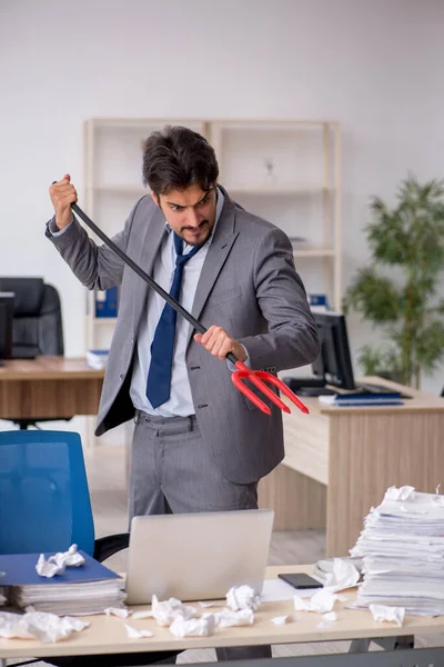 Young male employee and too much work in the office — Stock Photo, Image