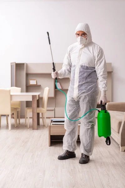 Jovem empreiteiro fazendo controle de pragas em casa — Fotografia de Stock