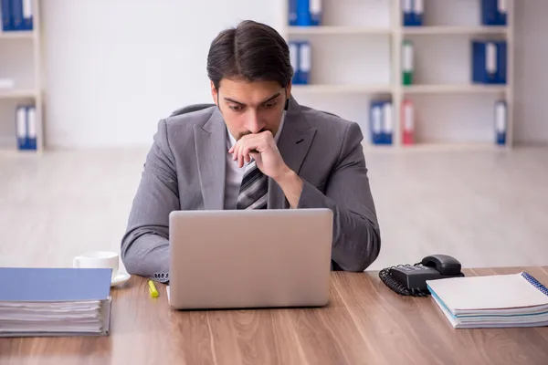 Young attractive male employee sitting at workplace — Stock Photo, Image