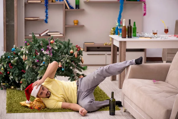 Jongeman schoonmaken van het appartement na kerstfeest — Stockfoto