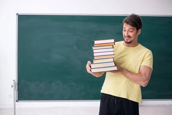 Jonge mannelijke student met veel boeken — Stockfoto