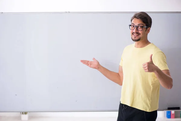 Jovem estudante do sexo masculino na frente do quadro branco — Fotografia de Stock