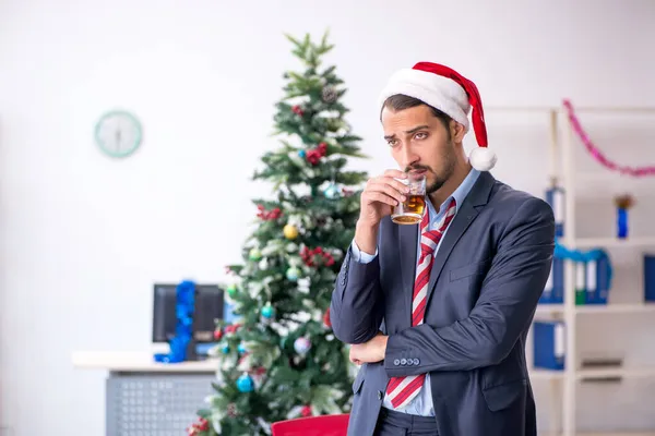 Jonge mannelijke werknemer viert Kerstmis op het werk — Stockfoto