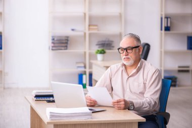 İş yerinde çalışan yaşlı bir erkek işçi.